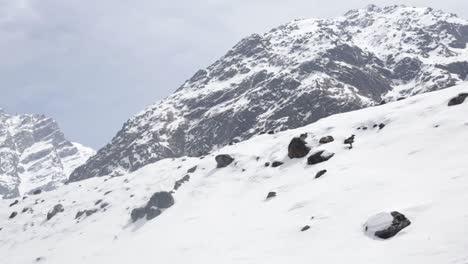 A-view-of-snowy-mountain-of-Himalayas,-Uttarakhand-India-and-mountaineers-climbing-the-snowy-mountains-in-large-number