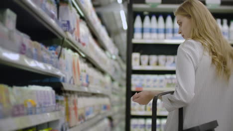 woman-choosing-and-buying-fresh-organic-dairy-products-at-grocery-store