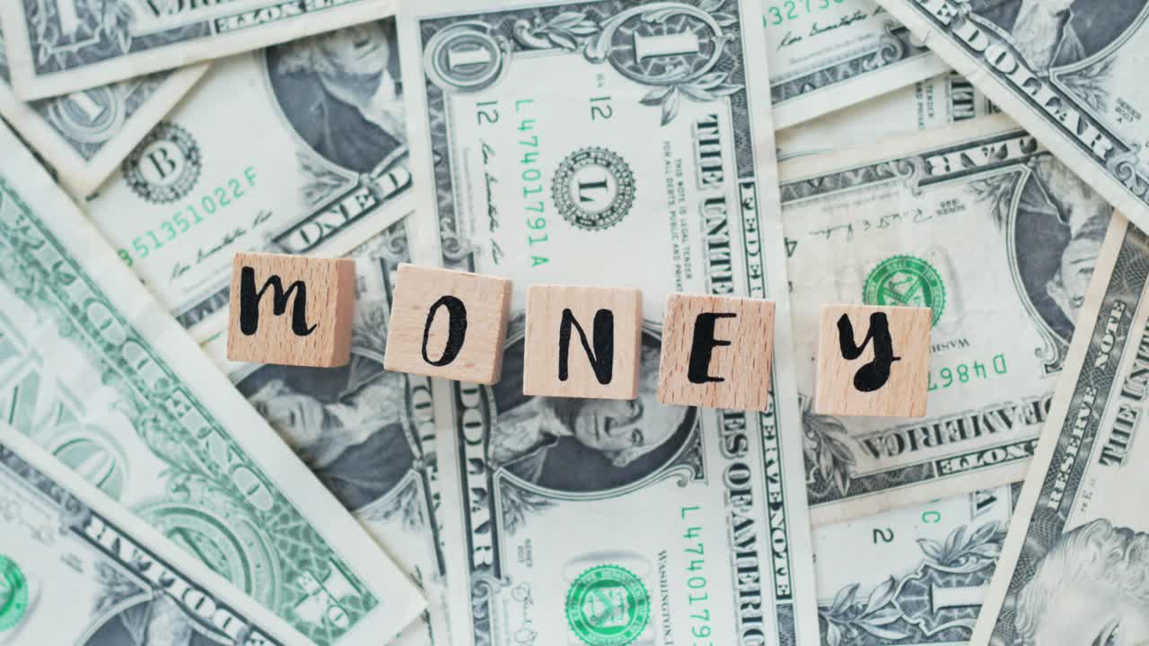 dinero de palabra giratoria de letras de madera, en dólares, concepto