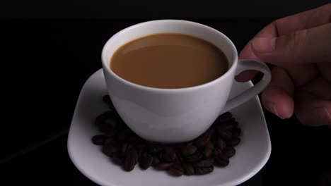 close up of hand pick up hot ceramic white coffee cup