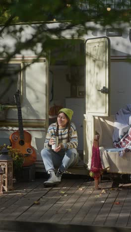 woman relaxing in a camper van on a sunny autumn day