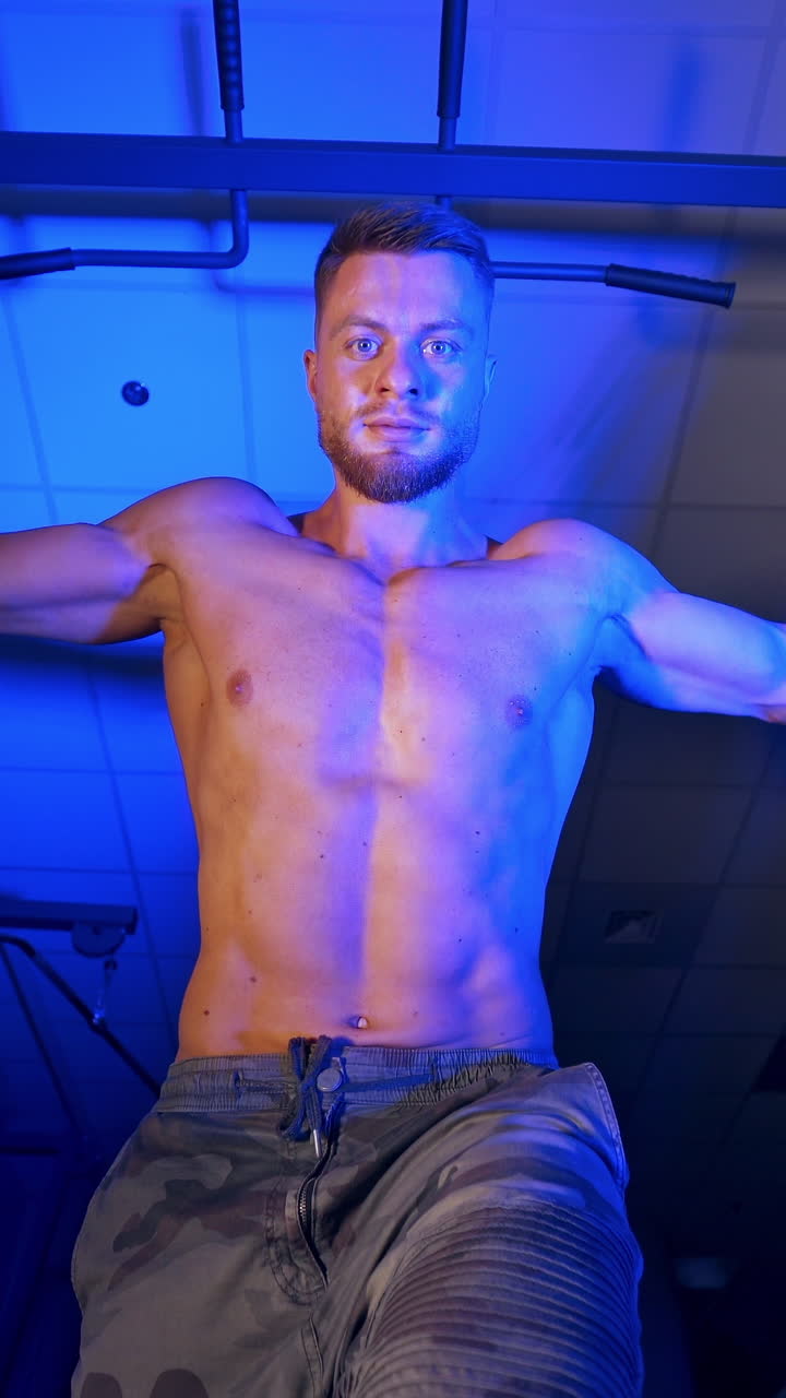 Athlete with strong body doing work out pushing up excercise in gym. View from the bottom. Vertical video
