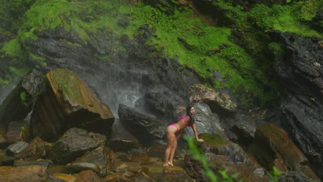 amidst the natural beauty of trinidad, a girl in a bikini poses by a stunning waterfall.