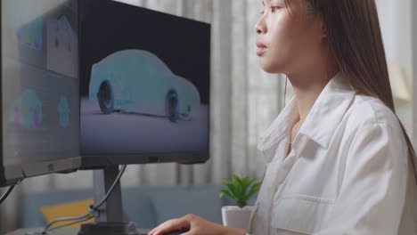아시아 여성 자동차 디자이너가 스튜디오의 데스크 컴퓨터에서 ev 자동차의 3d 모델을 작업하는 동안 커피를 마시고 있는 근접한 측면 뷰