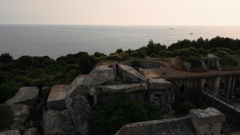 Vista-Aérea-Cinematográfica-Círculo-De-Drones-Sobre-Una-Fortificación-Histórica-De-La-Primera-Guerra-Mundial-Fortaleza-Junto-Al-Mar-Junto-Al-Idílico-Mar-Mediterráneo-Adriático-Con-Agua-Azul-Y-Playas-Escondidas-Para-Viajar