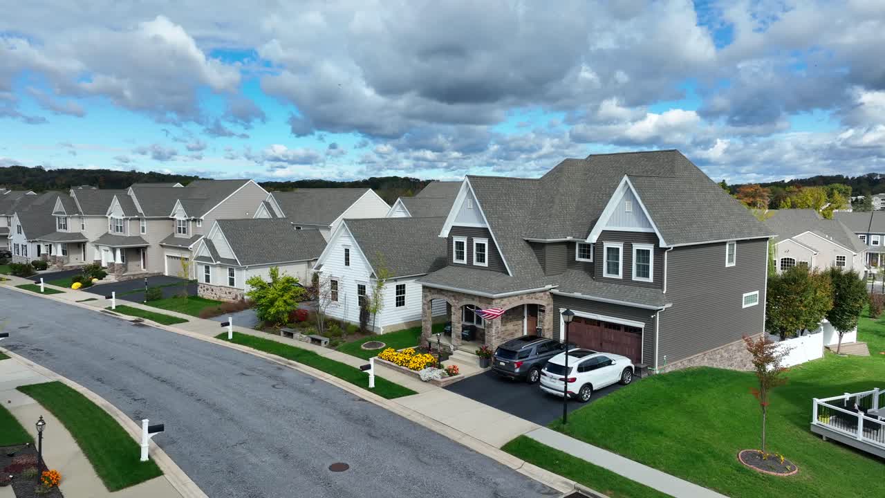 Suburban street with uniform houses, manicured lawns, and cloudy skies