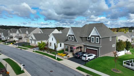 suburban street with uniform houses, manicured lawns, and cloudy skies