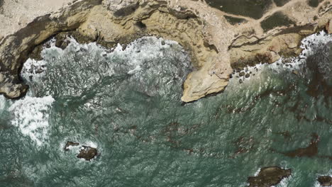 Vista-De-Pájaro-Mirando-Hacia-Abajo-Sobre-Los-Mares-Verdes-Y-Los-Escarpados-Acantilados-Y-El-Antiguo-Faro-En-El-Refugio-De-Vida-Silvestre-Morrillos-En-Cabo-Puerto-Rico-En-El-Mar-Caribe