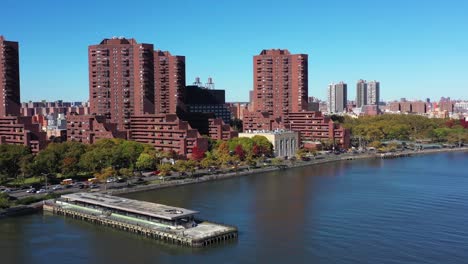 drone se aleja de los edificios de apartamentos de gran altura a lo largo del río harlem en manhattan, nueva york