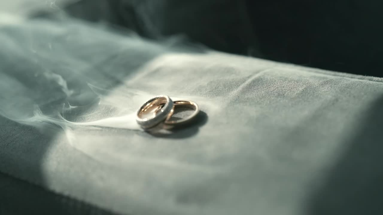 Closeup at smoking golden Luxury Wedding Rings in Romantic detailed Atmosphere