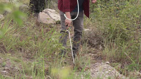 hombre en el bosque regando nuevos árboles, pesticidas o fertilizantes, usando un rociador de mochila