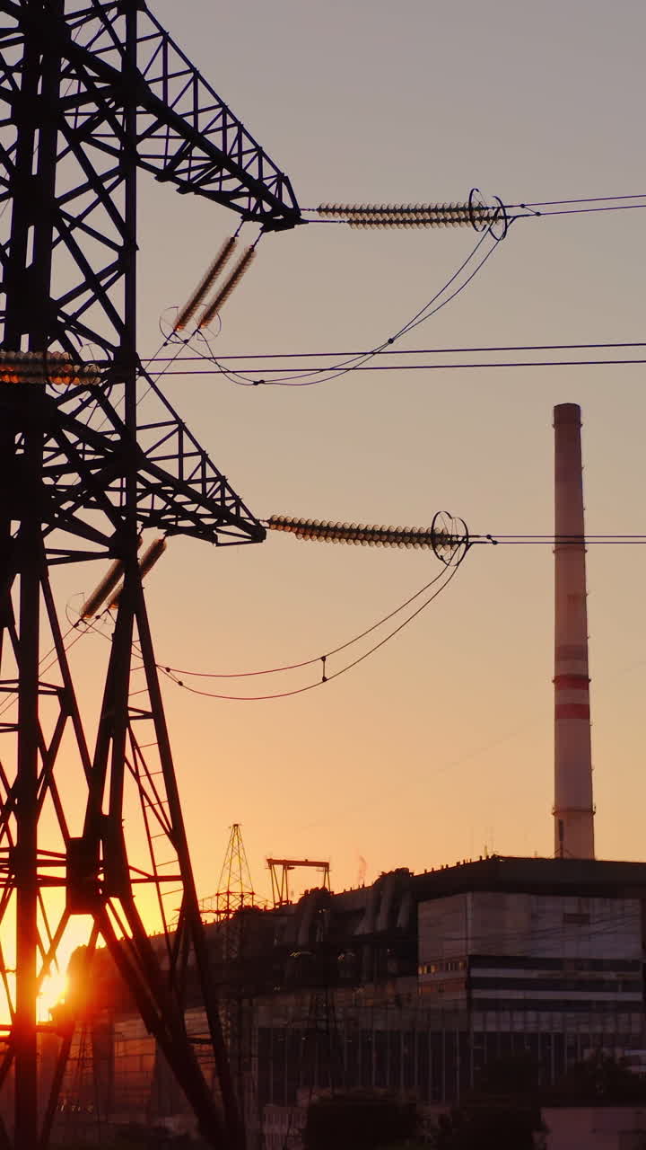 Beautiful sunset over power lines. High voltage power tower landscape at sunset. Vertical video