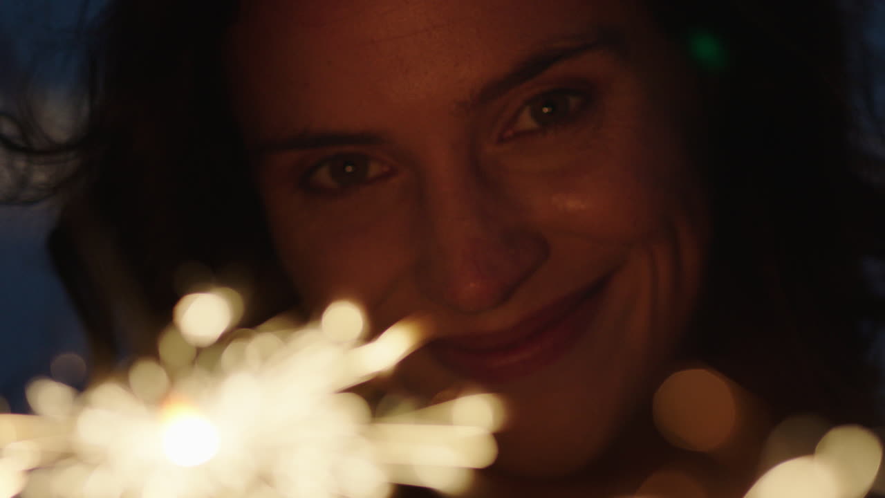 close up sparklers portrait of attractive woman celebrating new years eve enjoying independence day celebration having fun at night