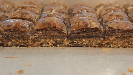 baklava turca con cacao y nueces de pino molidas. postre nacional del mediterráneo. disparo de muñecas. espacio de copia. primer plano, video en 4k.