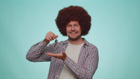 young adult man real estate agent showing keys of new home house apartment, buying renting property