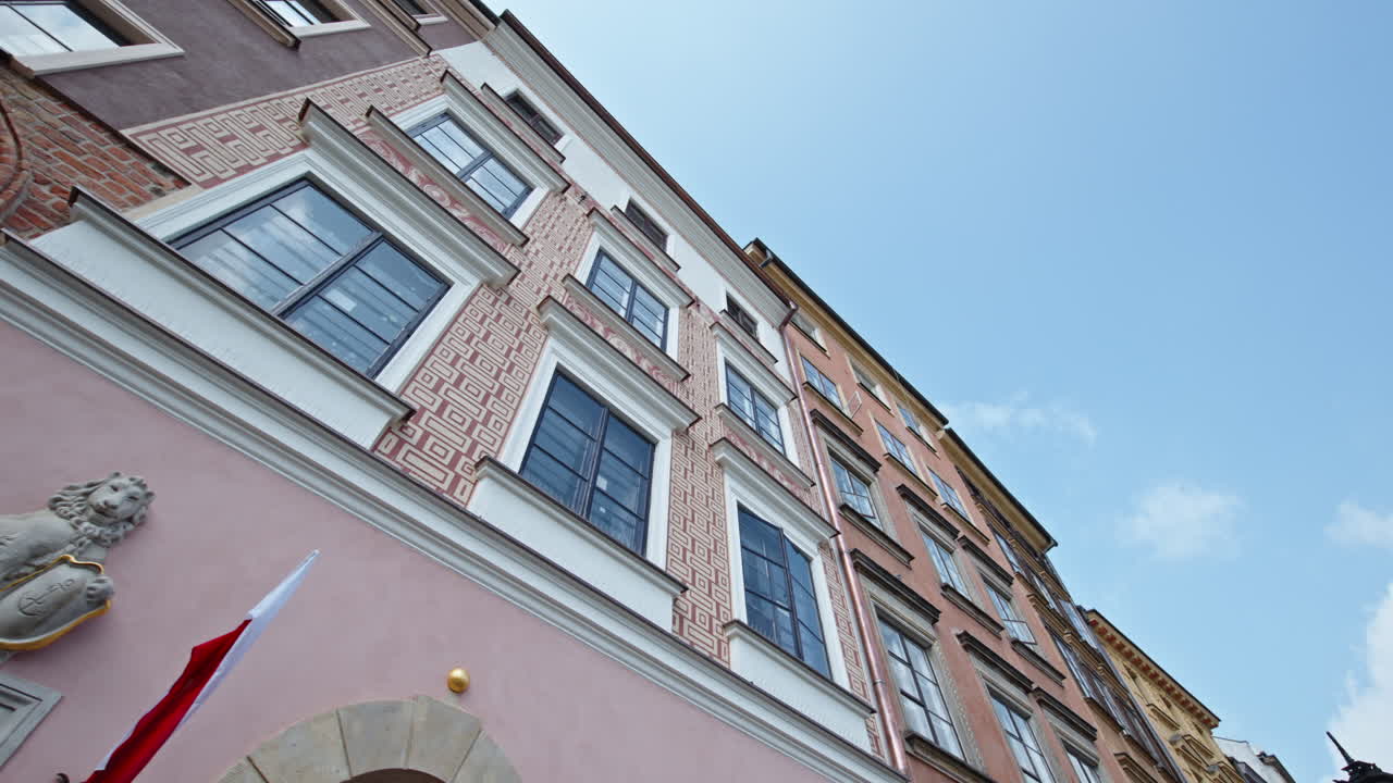The image shows the colorful architecture of Old Town Warsaw with classic buildings and windows