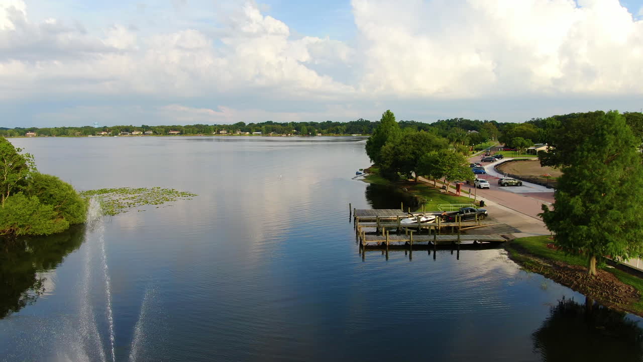 Panoramica su un bellissimo lago della Florida centrale con moli e una fontana in una sera di primavera.