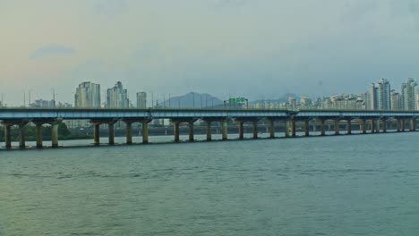 seoul city river urban town park with bridge in the evening with buildings and skyscrapers wide angle view panorama with water, waves and sky