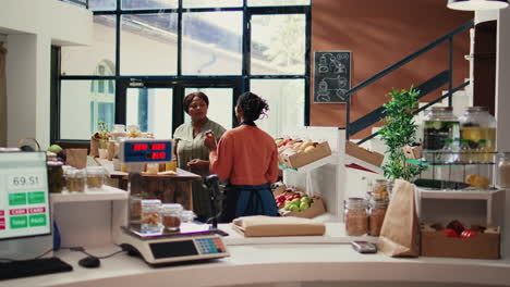 merchant offering food sample to regular customer