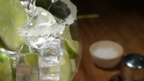 close up water filling fresh cocktail lemonade glass spinning , drink with soda, lemon slice, ice and mint