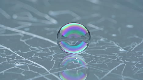 rainbow soap bubble on a cracked surface