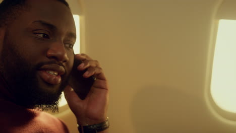 Rich-man-talking-phone-at-airplane-window-closeup.-First-class-passenger-enjoy