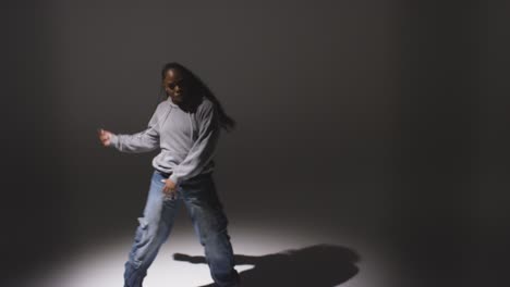 Full-Length-Studio-Portrait-Shot-Of-Young-Woman-Dancer-Dancing-In-Spotlight-With-Shadows-In-Foreground-1