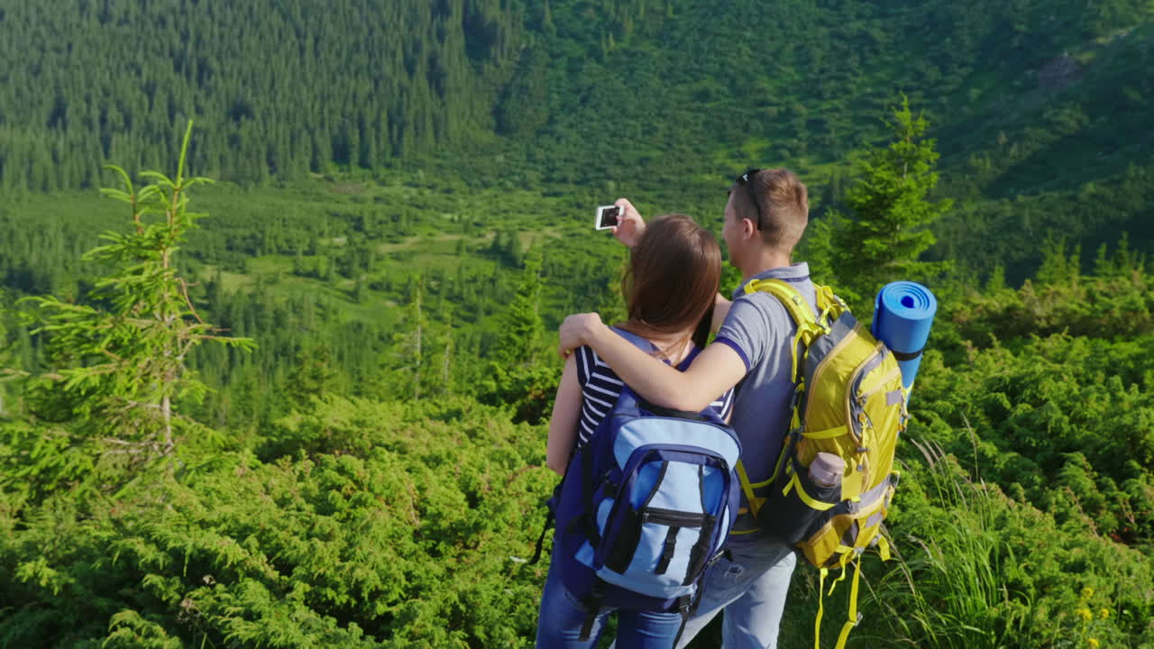 vacaciones en las montañas en verano un hombre toma fotos de su novia en un hermoso backgr