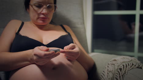 una mujer con una protuberancia de bebé a la vista tomando una prueba de diabetes