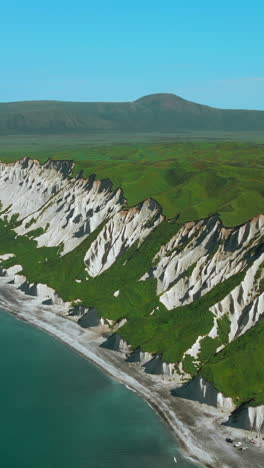 aerial view of a coastal landscape with cliffs and green hills