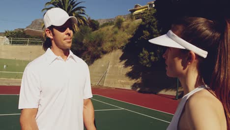 woman and man playing tennis on a sunny day