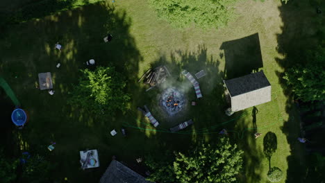 Top-down-bird's-eye-aerial-view-of-bonfire-in-country-house-in-summer