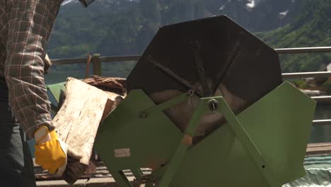 man cutting wood with a portable circular saw by a lake