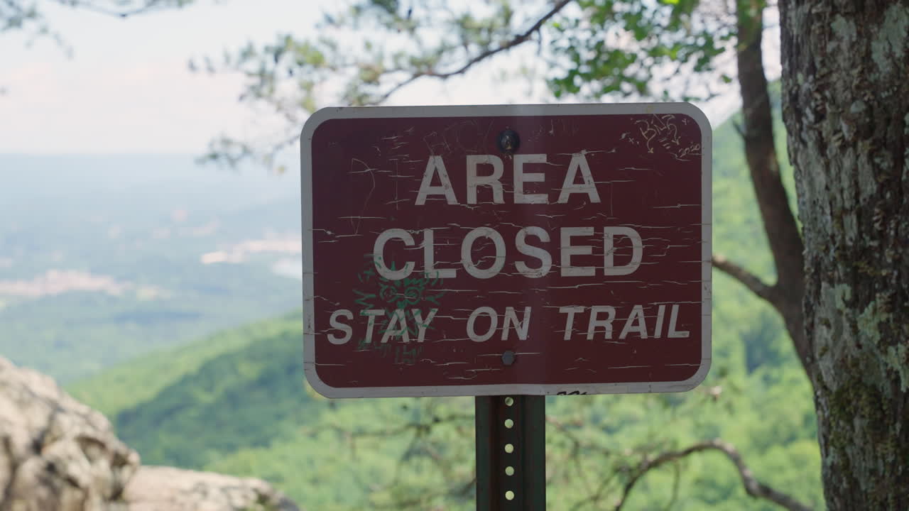 Brown sign in state or national park marking Area Closed. Signage for tourists and park visitors. Prohibited access to area for all hikers and bikers on trail. Warning notice on mountain forest