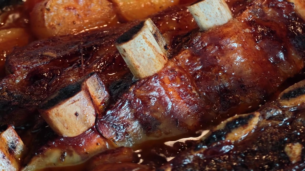 Top View of Slow Cooked Asado Beef Ribs in Rich Broth with Potatoes, Sweet Potato and Onion Boiling in Black Pot, Rustic Gourmet Meat Stew, Comfort Food Close Up