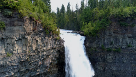 beautiful water fall through cliff on a sunny day 4k