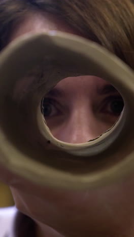 woman looking through a ceramic tube