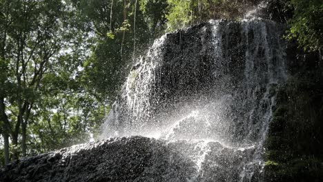 beautiful waterfall cascade surrounded by trees. rock formation overhang. water splash on drop. stunning sunlight shine on water drops. monasterio de piedra park, zaragoza, aragon, spain
