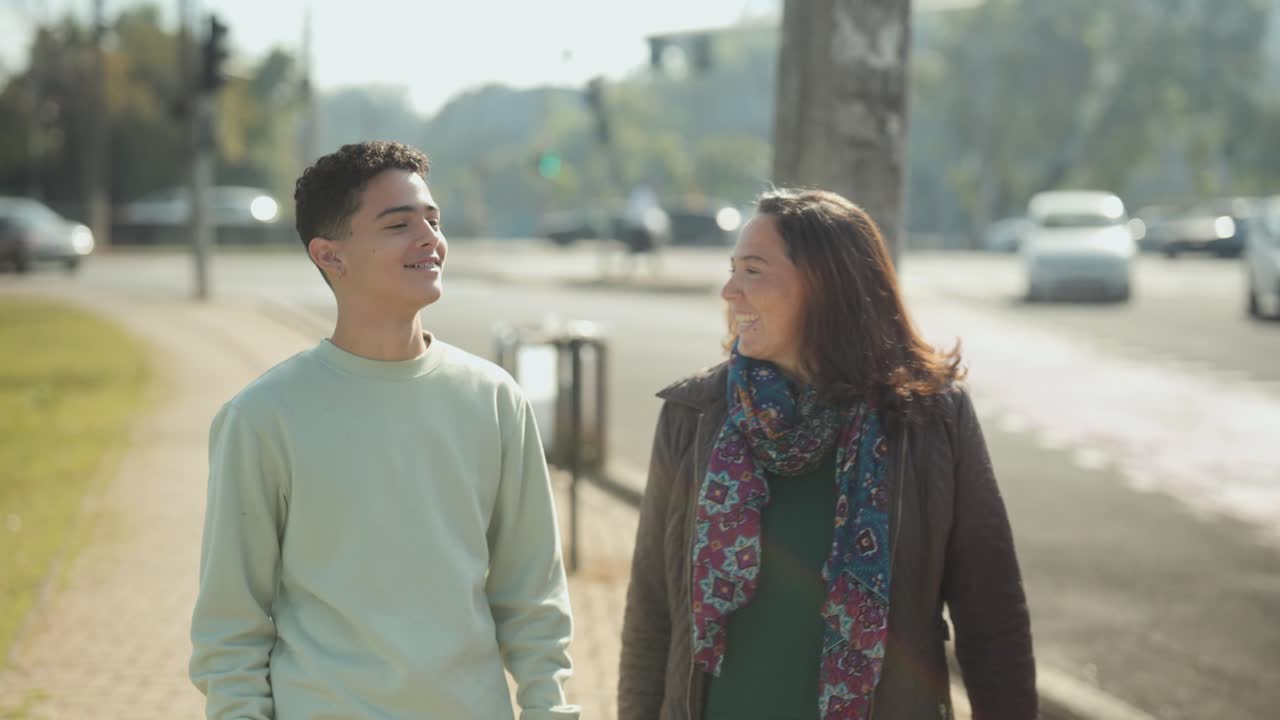 Two People Walking and Smiling on a City Street