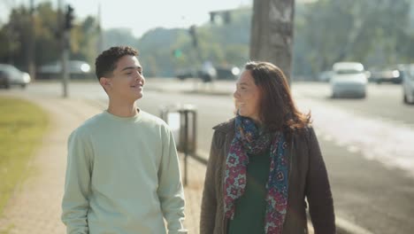 two people walking and smiling on a city street