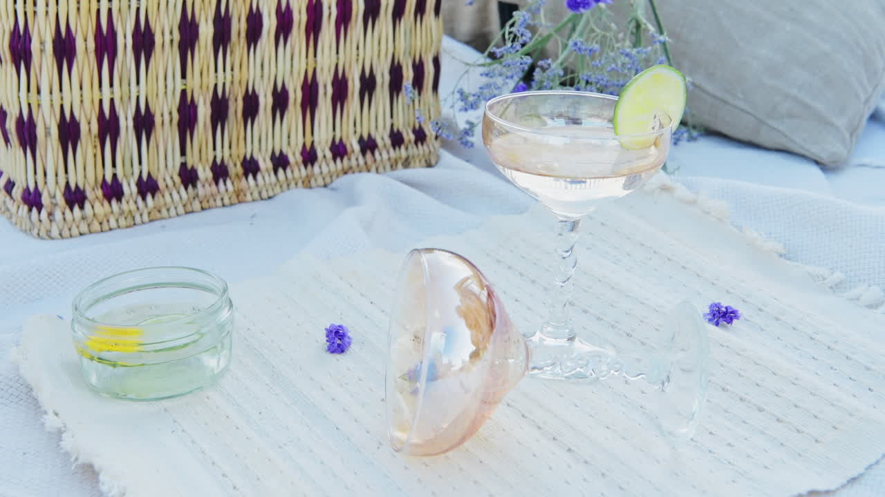 Putting A Glass Of Champagne To A Decorative Flat Lay Luxury Picnic in a Park with a Cocktail - close up