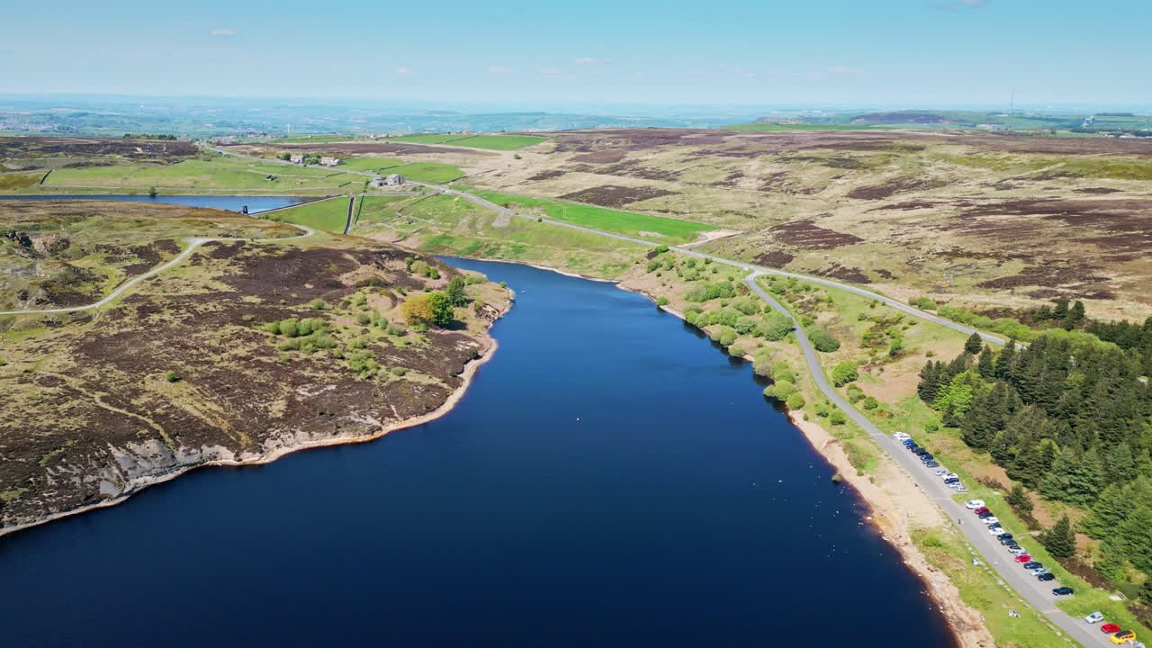 요크셔에 있는 윈스카르 저수지의 경치적인 아름다움에 몰입하십시오. 여기서 세일링 클럽 회원들은 활기찬 보트 경주에 참여합니다. 그들의  ⁇  세일은 매혹적인 광경을 만 ⁇ 니다.