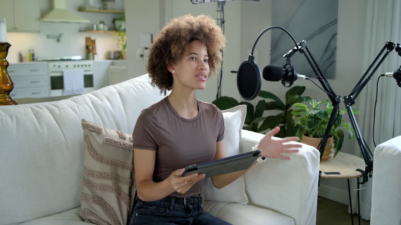 African American women recording, left host cueing tablet, reading and talking into mics in studio