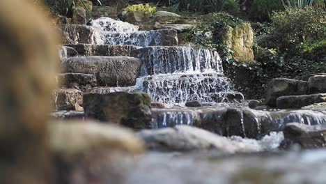 waterfall flowing over rocks in a garden