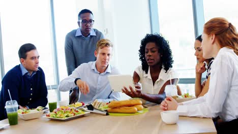 executives discussing over digital tablet