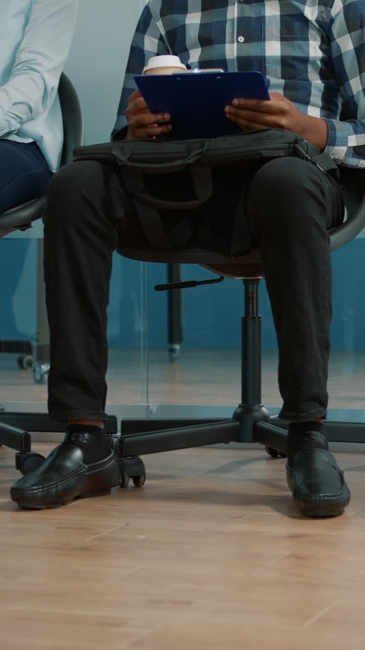 People sitting in chairs waiting for a job interview