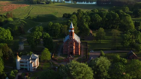 aerial view of church of the holy virgin mary in kernave, lithuania - drone pullback