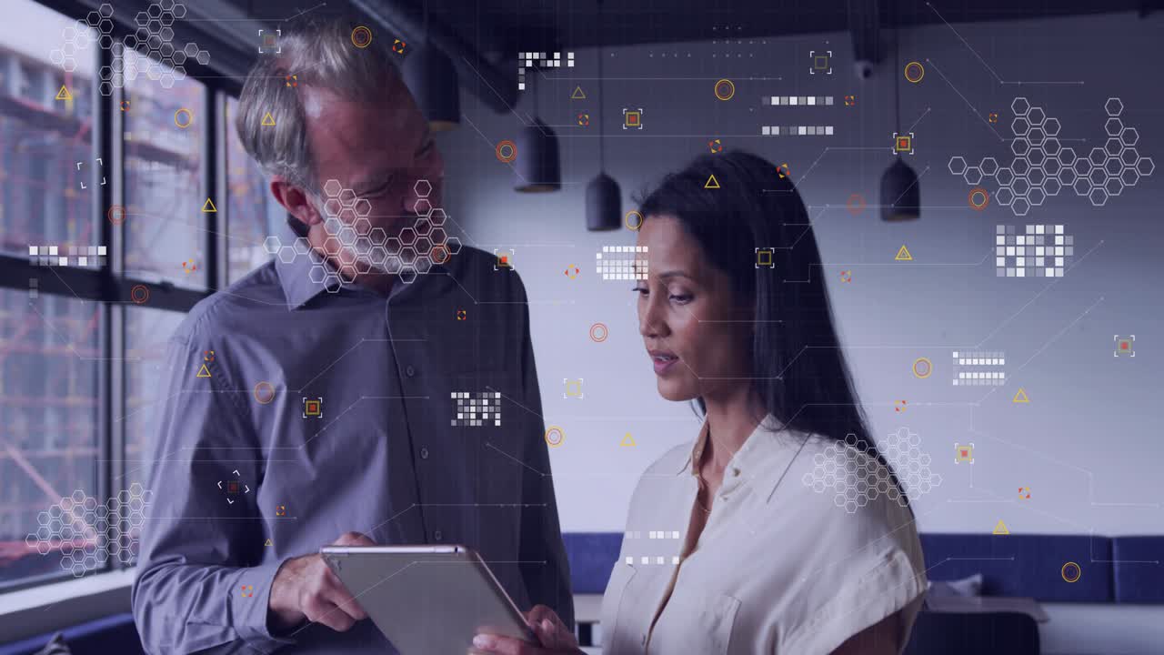 Man tapping tablet and woman holding tablet reviewing business data in office with growing graphs