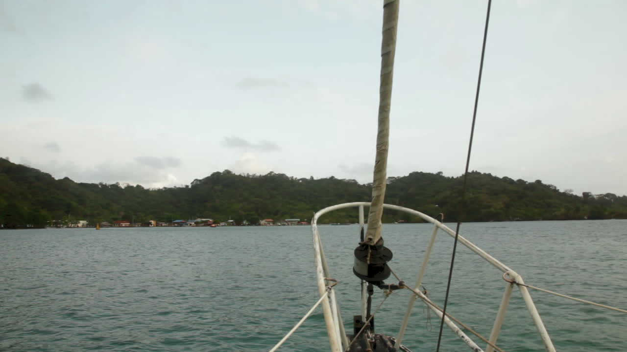 Looking out from the sailboat’s bow, Sapzurro Bay stretches quiet and green beyond.