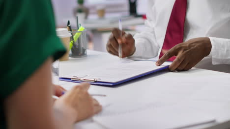candidato a la entrevista de empleo firmando su contrato de trabajo en la oficina